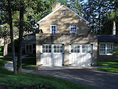A stucco building with a pair of double garage doors.