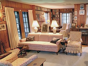 A room with knotty pine walls and cozy upholstered furniture.