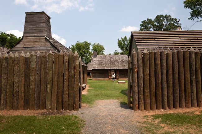 A large timber fence encircles a wooden fort.