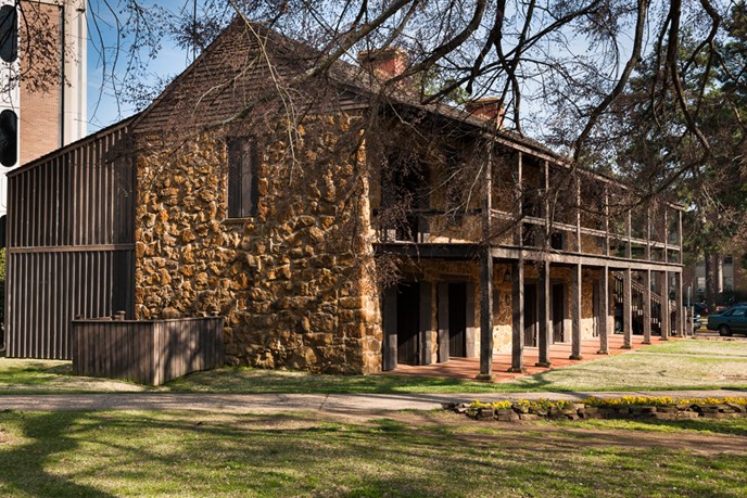 large stone fort with extensive balcony, green grass, tree limbs hanging down large stone fort with extensive balcony, green grass, tree limbs hanging down