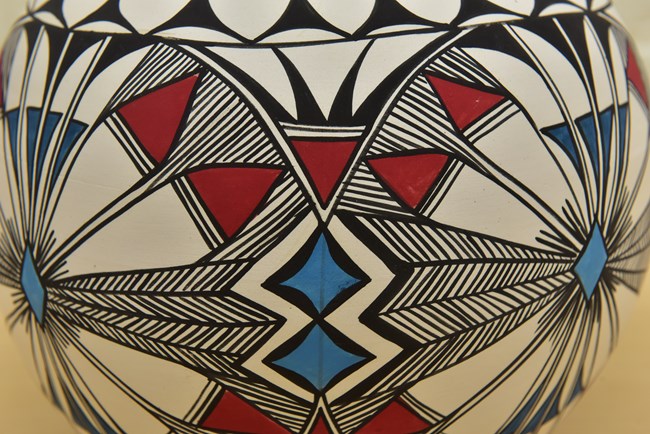 Detalle del diseño geométrico de una olla cerámica con colores negro, rojo y azul