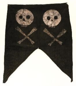 Banderín de tela negra con calavera y tibias cruzadas pintadas en blanco.