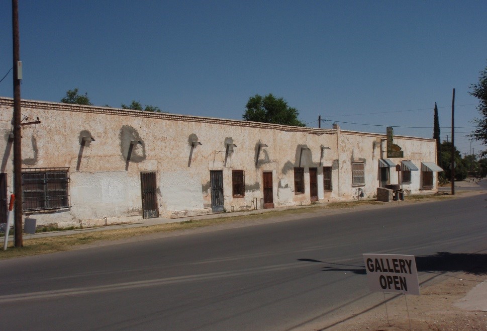 asphalt road and a long white, one store building, old spanish style, washed up