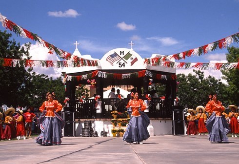women with mexican dancing style colorful dresses with mexican flags in the back