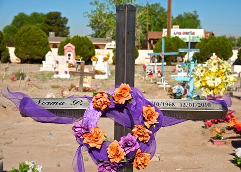 image of a metal cross with a crown and flowers