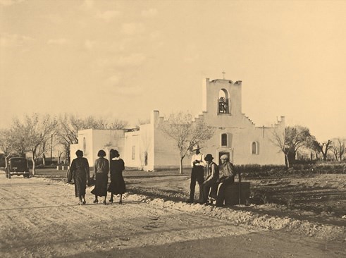 historical black and white photo of church and people walking outside