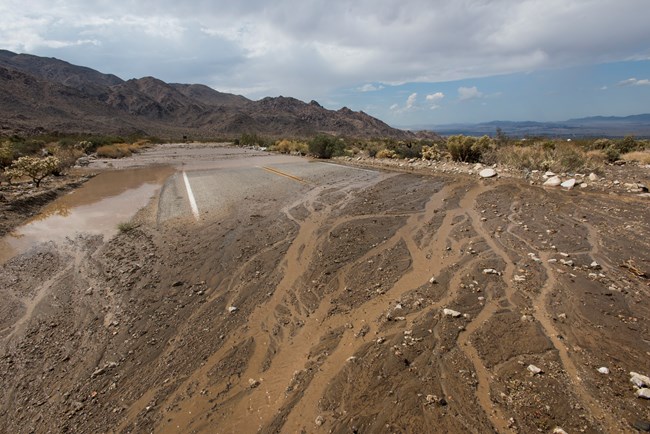 Agua y escombros en la carretera a causa de una inundacion.