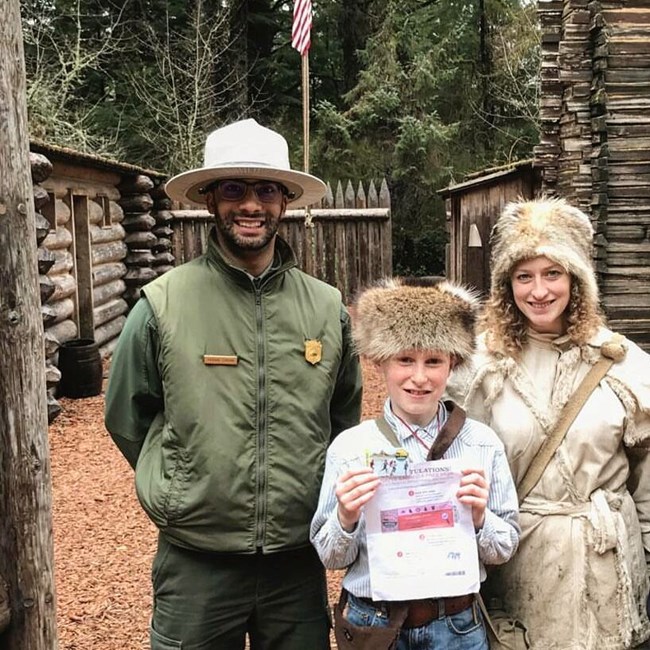 Dos guardaparques y un menor con su every kid in a park pass. Dos guardaparques y un menor con su every kid in a park pass.