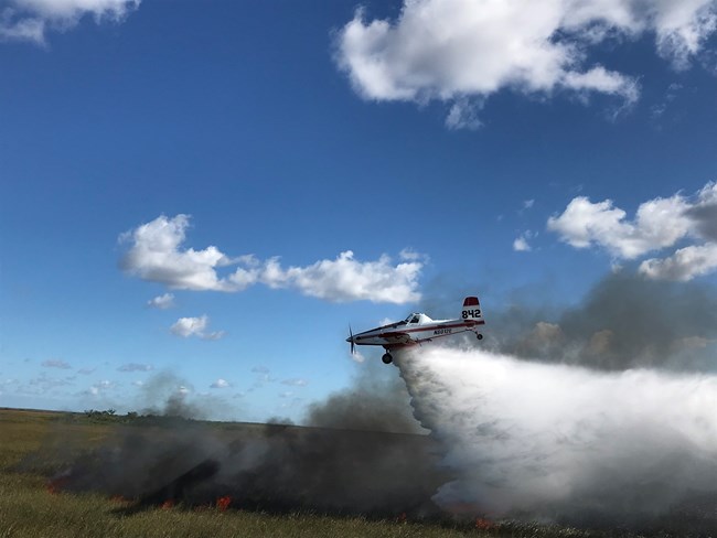 A plane spraying water on a fire
