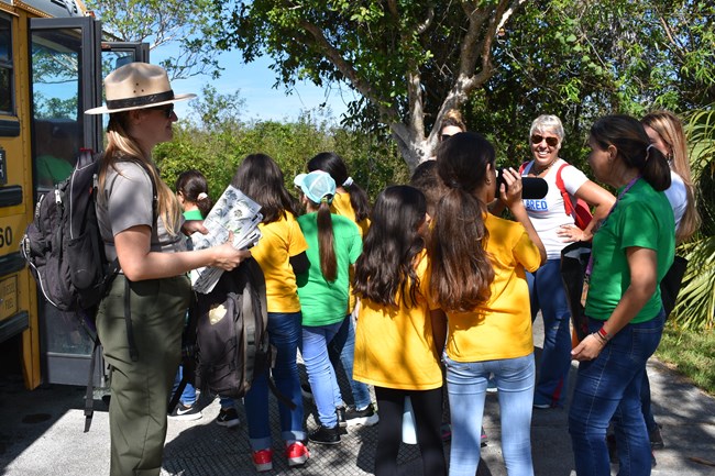 Ranger Dylann welcoming students off a school bus