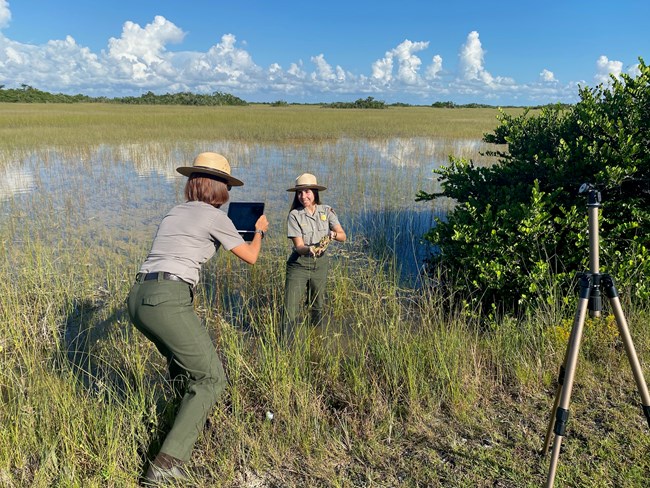 Park Ranger being filmed, holding periphyton up to the camera
