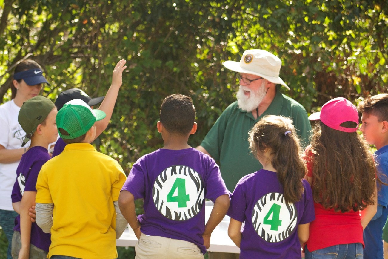 A volunteer speaks to a group of school children
