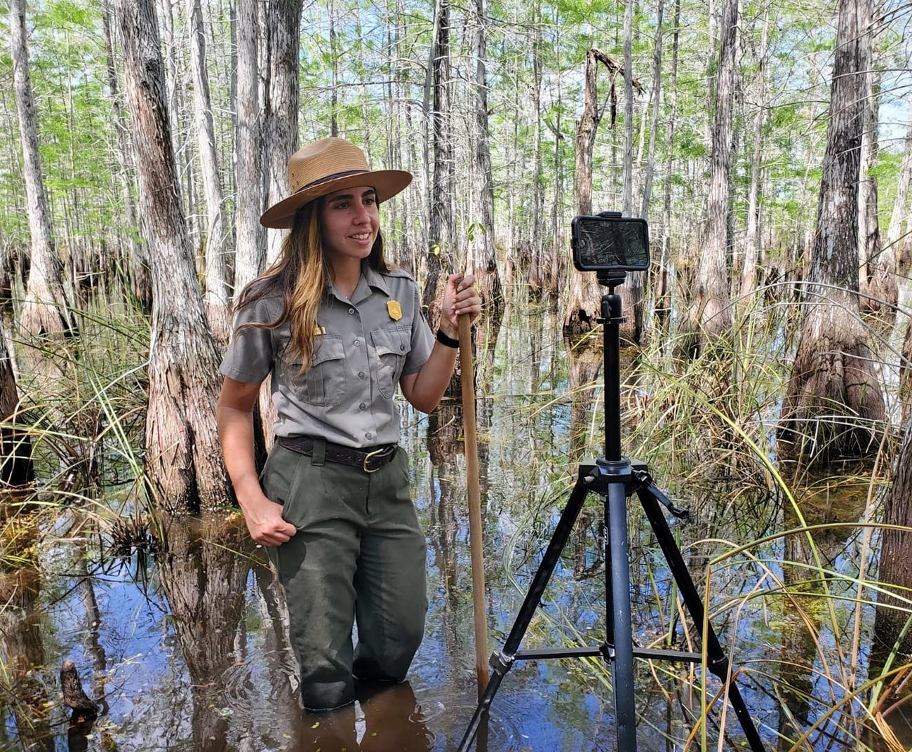 a ranger stands in water in front of an iphone