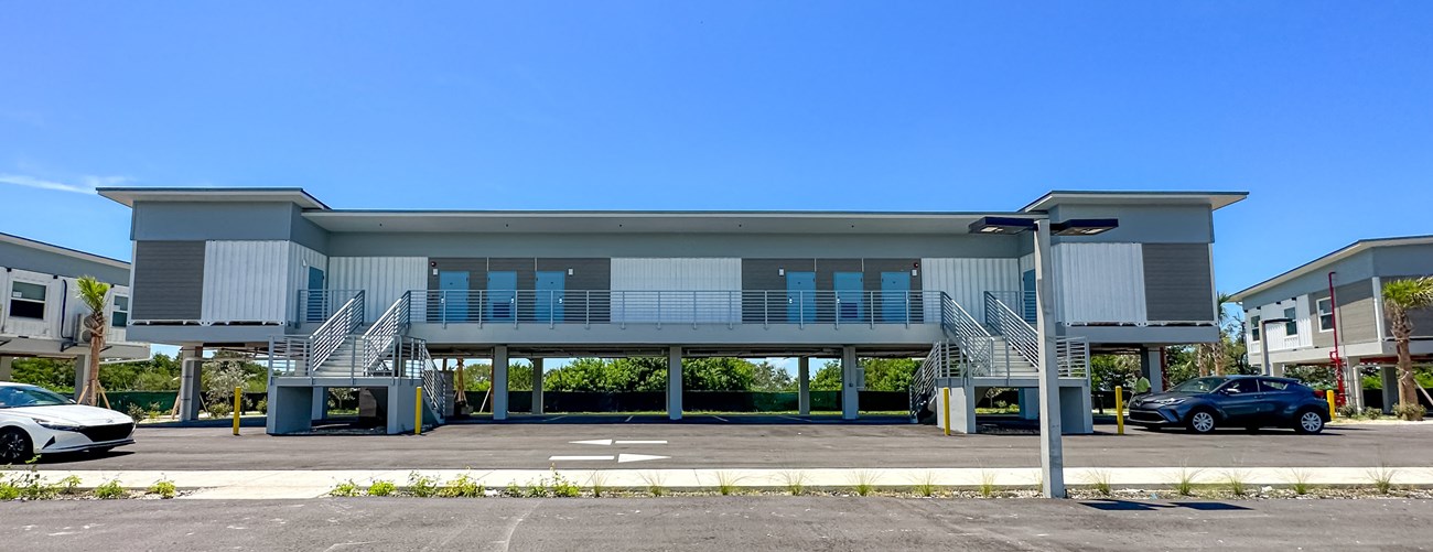 Two story building made of shipping containers with stairs in front