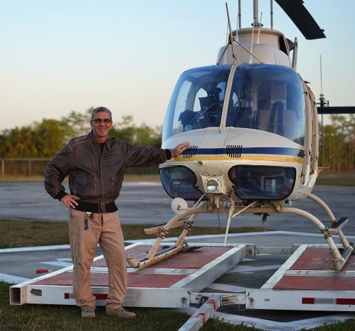 Fred Goodwin, NPS Fleet Pilot, stands next to helicopter Fred Goodwin, NPS Fleet Pilot, stands next to helicopter