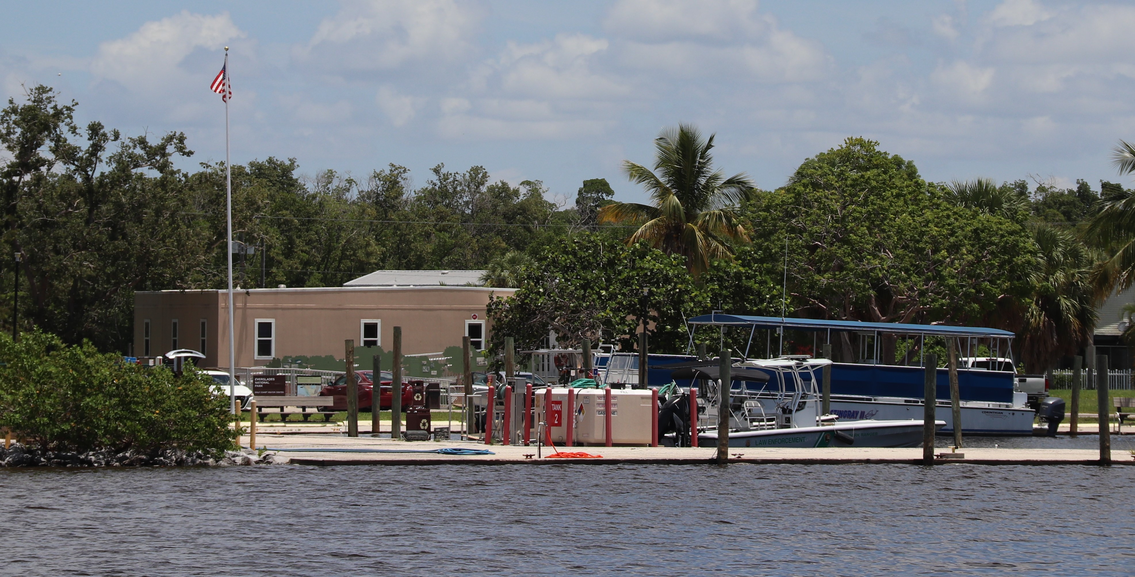 A view from the water of a building and a marina with two boats,