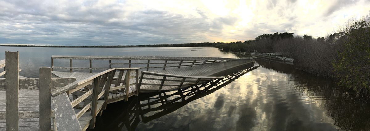 a twisted boardwalk is shown over a body of water