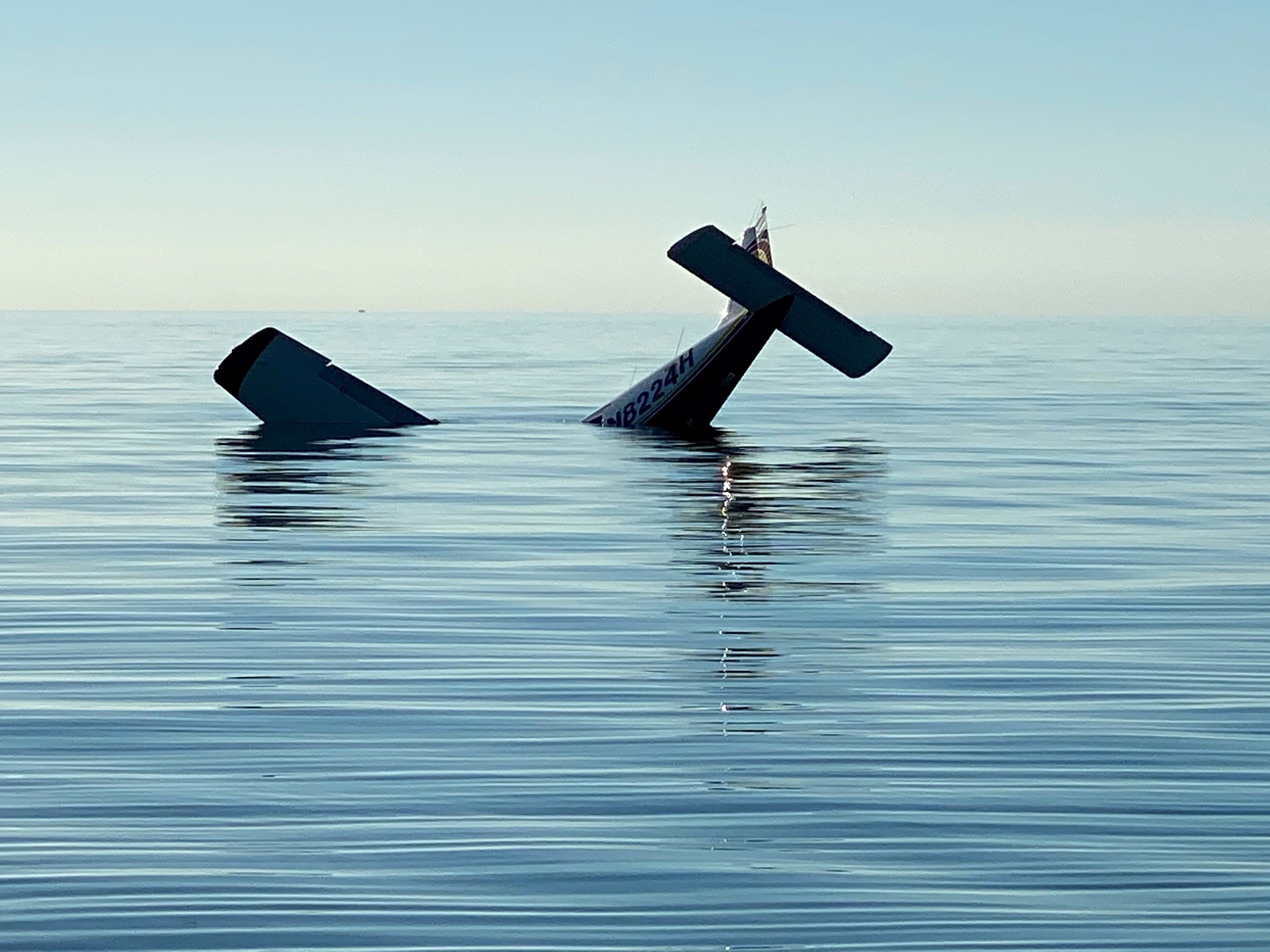 Plane crash near Cape Sable 1-22-21 NPS Photo by reporting party The tail and one wing of a submerged airplane protrude from calm blue water under clear blue sky.