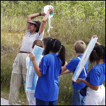 Park Volunteer Presenting Environmental Education Activity To School Group
