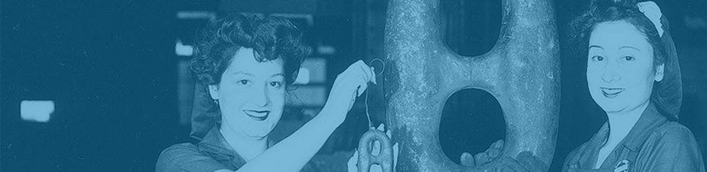 Image with a blue tint applied show two women smiling standing on either side of a large link of chain that is much larger than their heads. The woman on left holds a smaller link about the size of her hand.
