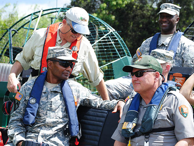 Senior officials riding in an air boat.