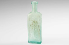 Rectangle-shaped aged aqua medicine bottle with stamped words.