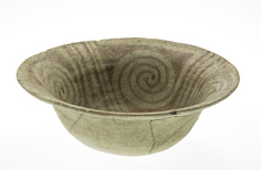 Aged cracked bowl with patterns on the inside.