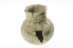 Aged cracked pot with large piece missing from it.
