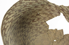 View from above of aged cracked bowl with large piece missing from it and patterns on the inside.