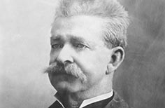 Portrait of a man in a suit with a mustache.