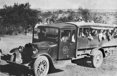 Children ride in an old fashioned school bus.