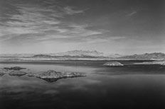 Large body of water with multiple islands, mountains in the distance.