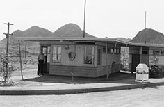 Small building with National Park Service sign on it and man standing in doorway.