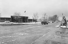 Cars on road in front of National Park Service building with small amount of snow.