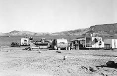 Several trailers and food truck next to nearby lake.