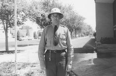 Man in uniform poses while wearing a helmet.