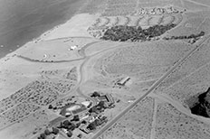 Aerial view, lake top left, trees and campsites center, buildings at bottom, multiple roads throughout.