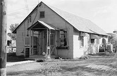 Small building with steeply sloped roof and small porch.