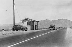 Small building on the side of the road with person standing nearby.