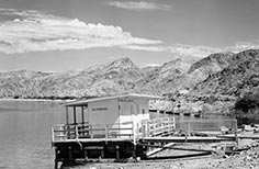 Dock on shore has small building with sign that reads No Fishing.