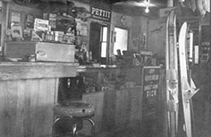 Interior of store counter with stool,  lined up water skis at right.