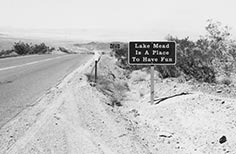 Sign next to road that  reads Lake Mead is a Place to Have Fun.