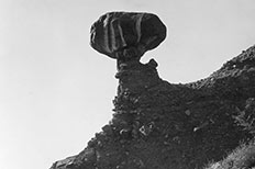 Large boulder balanced on top of a smaller rock formation.