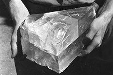 Large slab of salt crystal is showcased as two hands hold it.