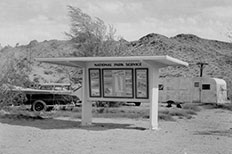 Sheltered display Lake Mohave Region information,  parked car and camper in the background. 