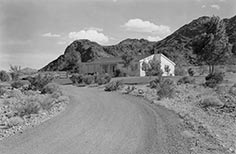 House at the end of a road up against a mountain.