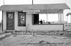 Small building with boarded up window.