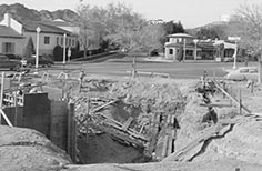 Construction site with hole and partial building framework.