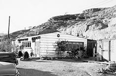 Small building with two cars parked in front.