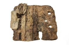Aged piece of metal tube with a hole.